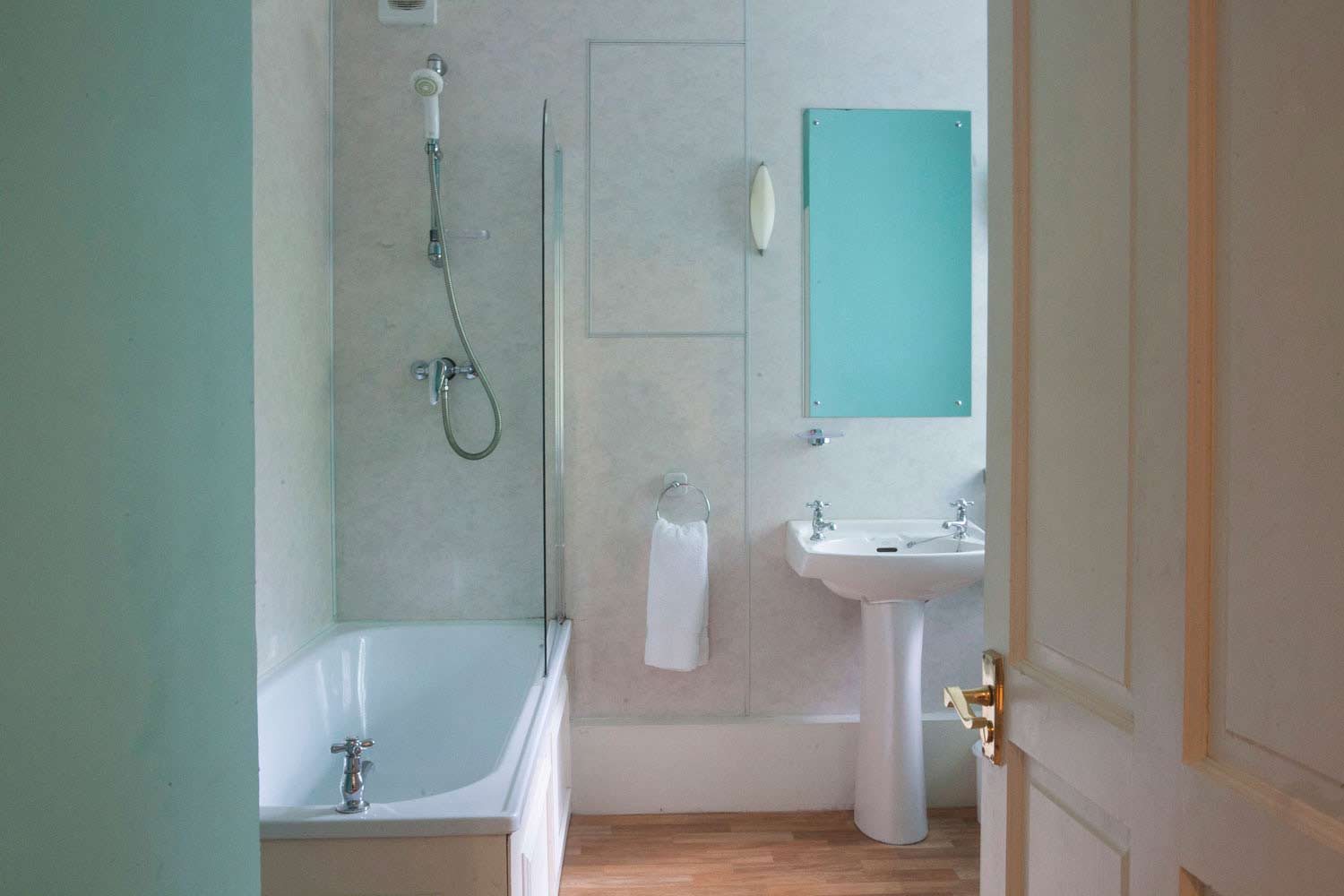 The bathroom has WC, handbasin, bath with shower over